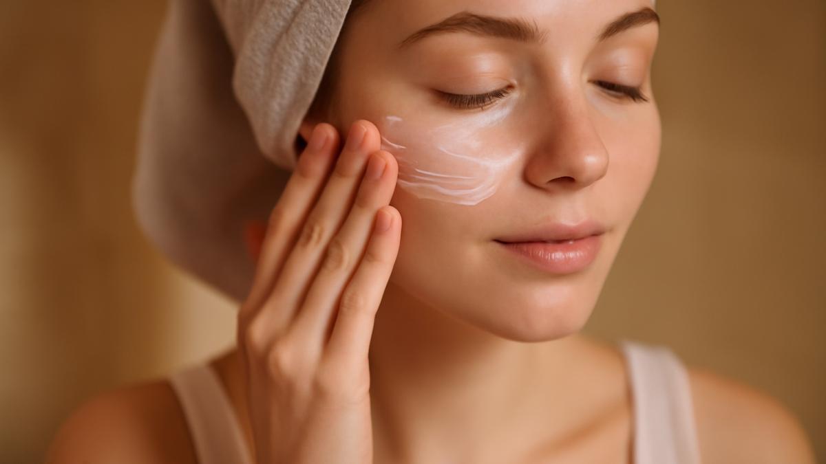 Женщина наносит увлажняющий бальзам на лицо