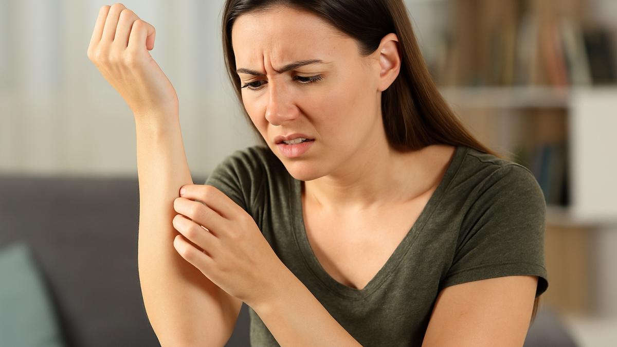 Женщина с тревогой смотрит на руку