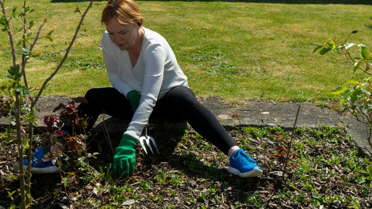 Садовод удаляет сорняки