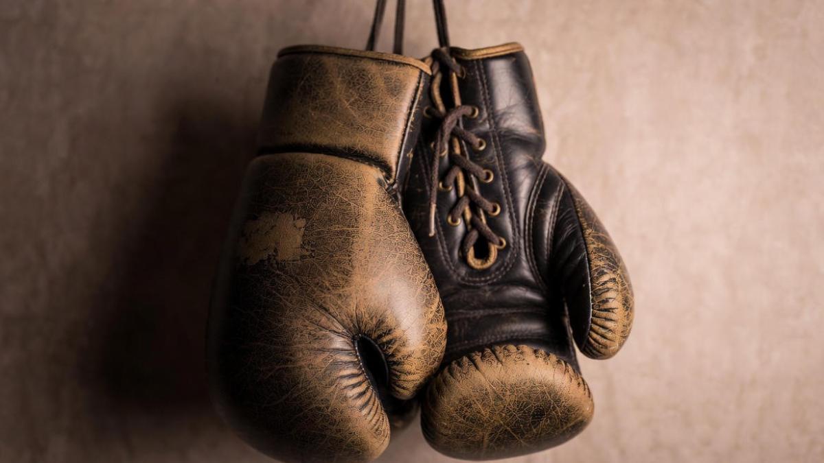 Боксерские перчатки, висящие на стене (старая кожа)