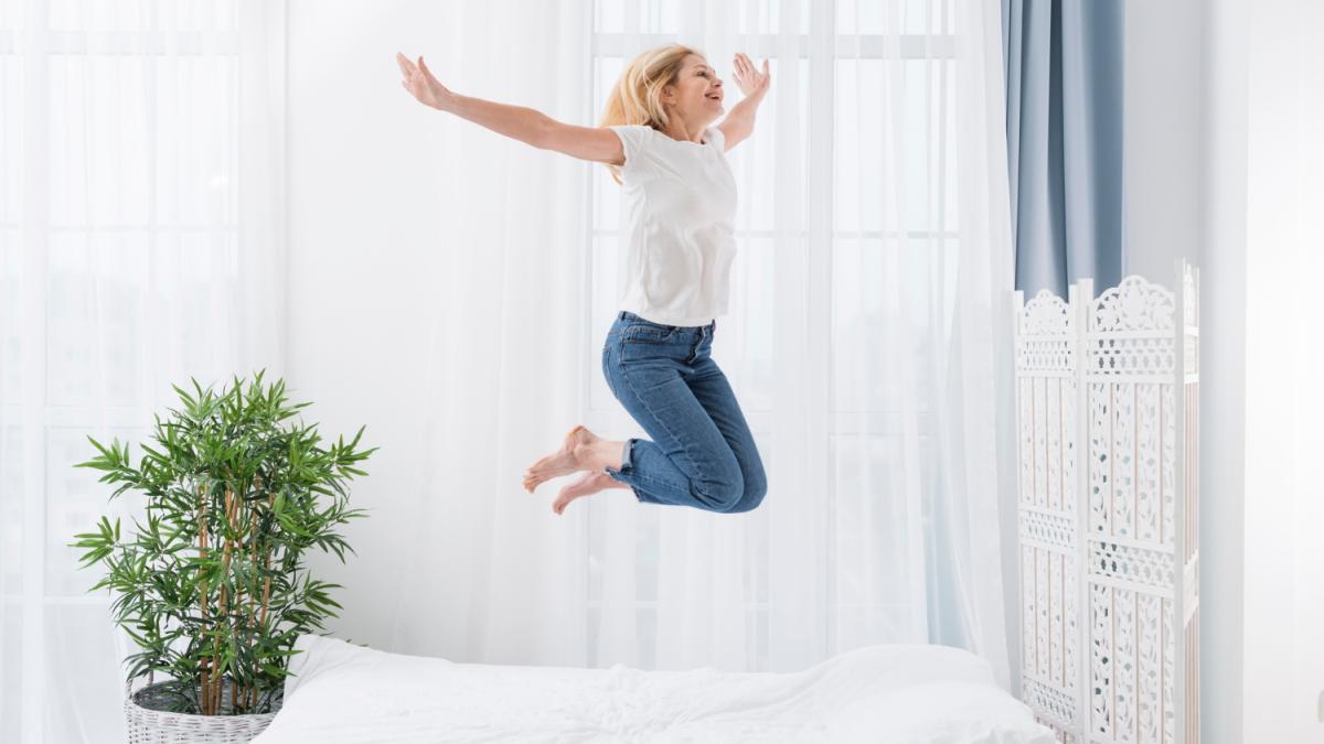 Женщина прыгает в постели