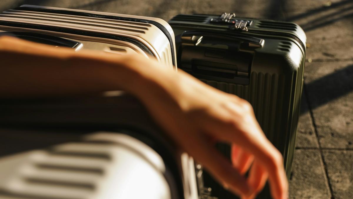 Чемодан на колесиках в зале аэропорта (крупный план)