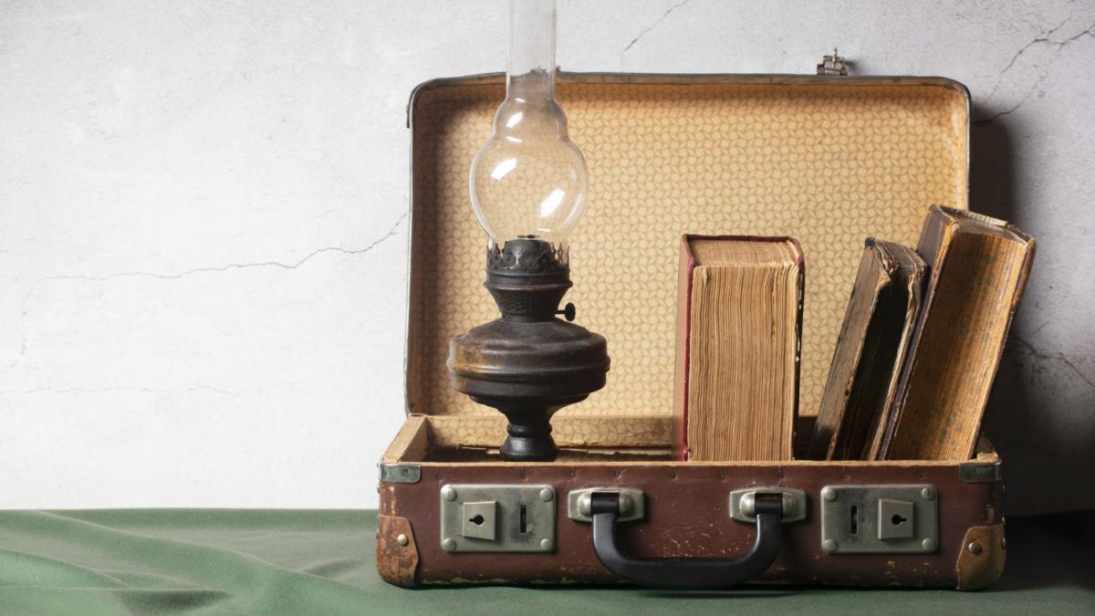 Старинный чемодан с книгами и лампой Старинный чемодан с книгами и лампой