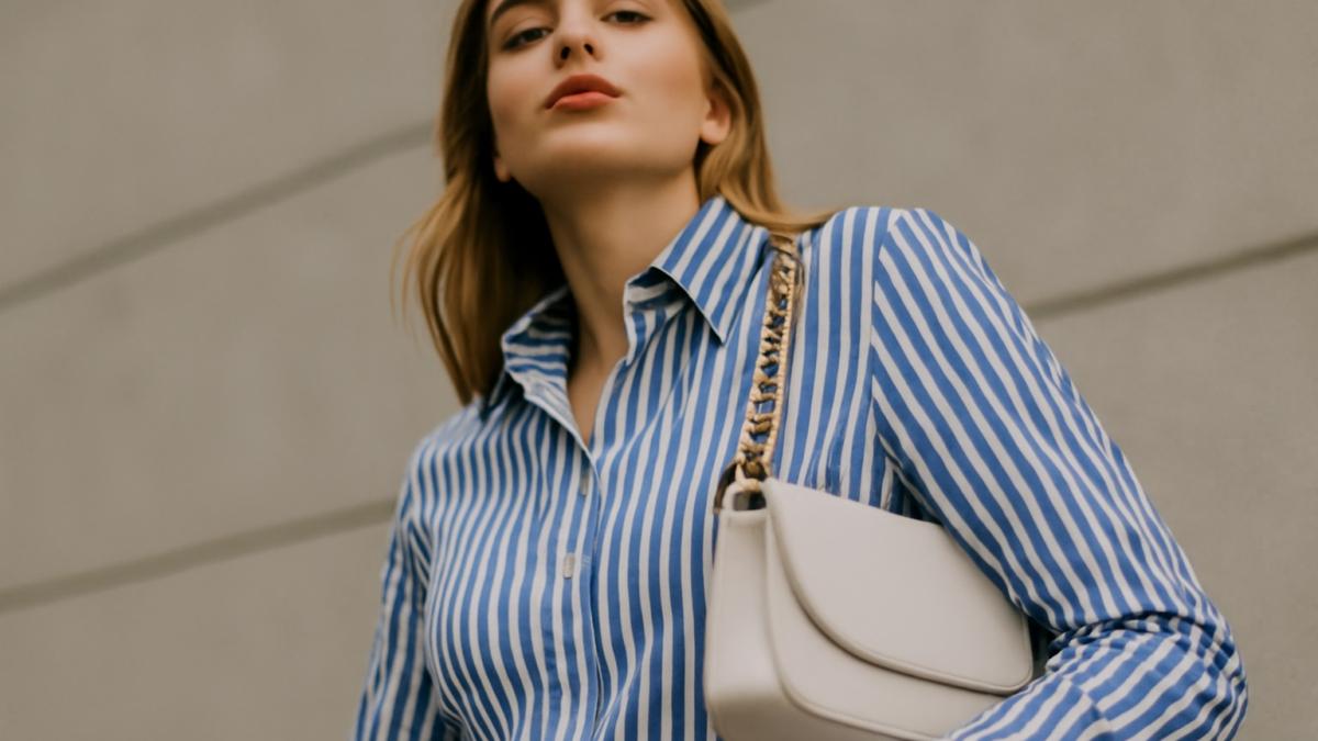 Женщина в полосатой рубашке с белой сумкой