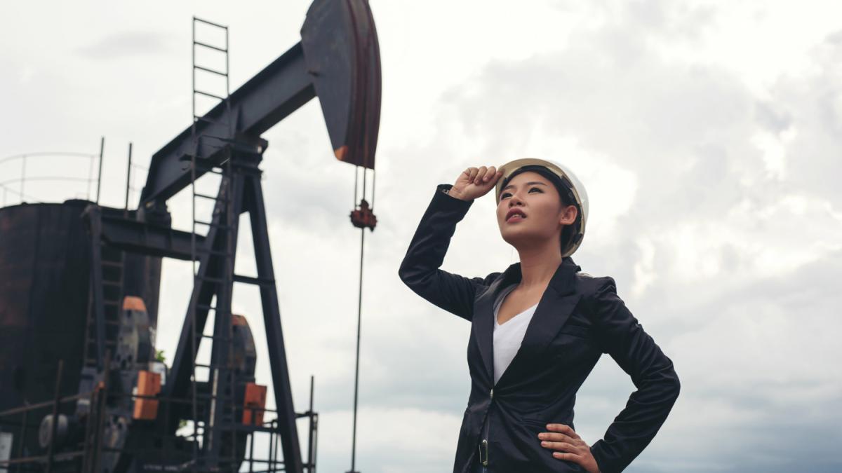 Женский инженер стоит рядом с насосами