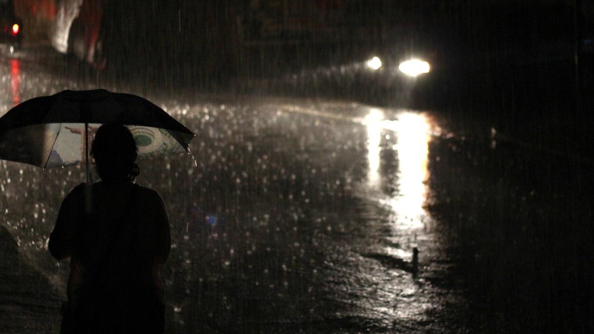 Человек под дождём с зонтом в руке