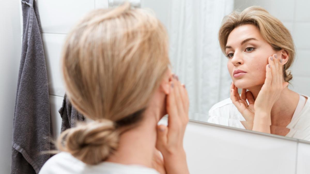 Женщина смотрит в зеркало