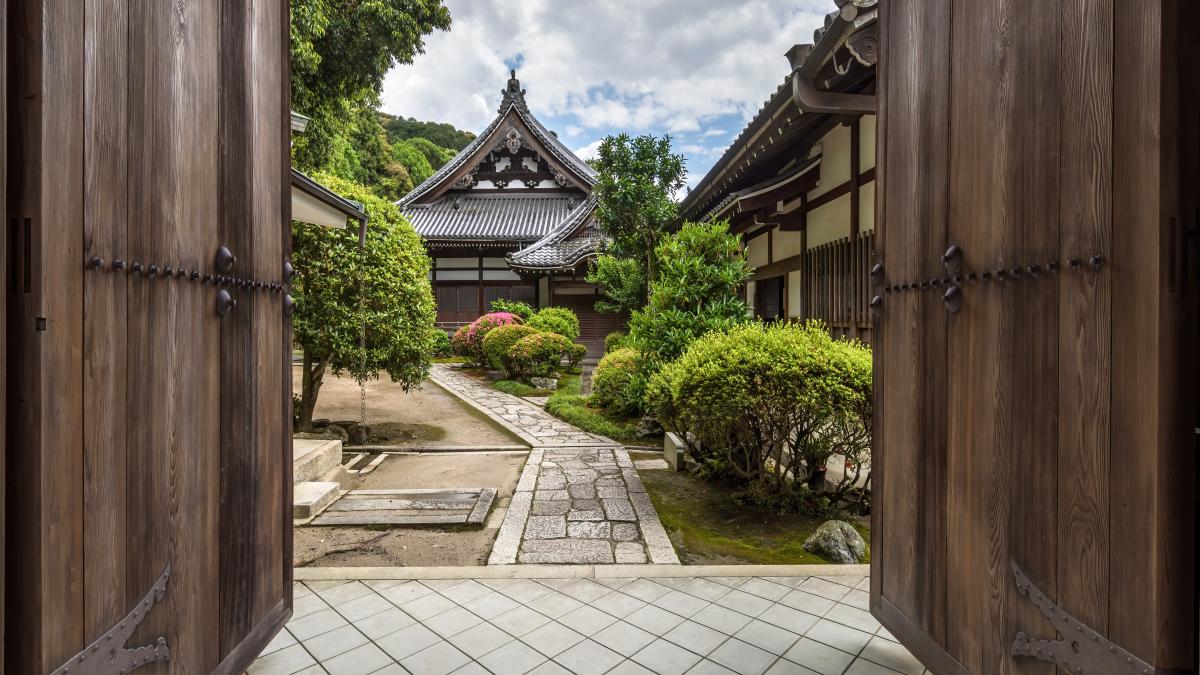 Wooden gate with open double door leading to the garden of Isshinin Buddhist temple in the compounds of Chion-in Kyoto Japan Wooden gate with open double door leading to the garden of Isshinin Buddhist temple in the compounds of Chion-in Kyoto Japan
