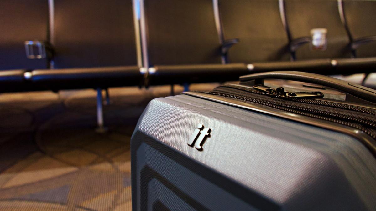 Чемодан на колесиках в зале аэропорта (крупный план)