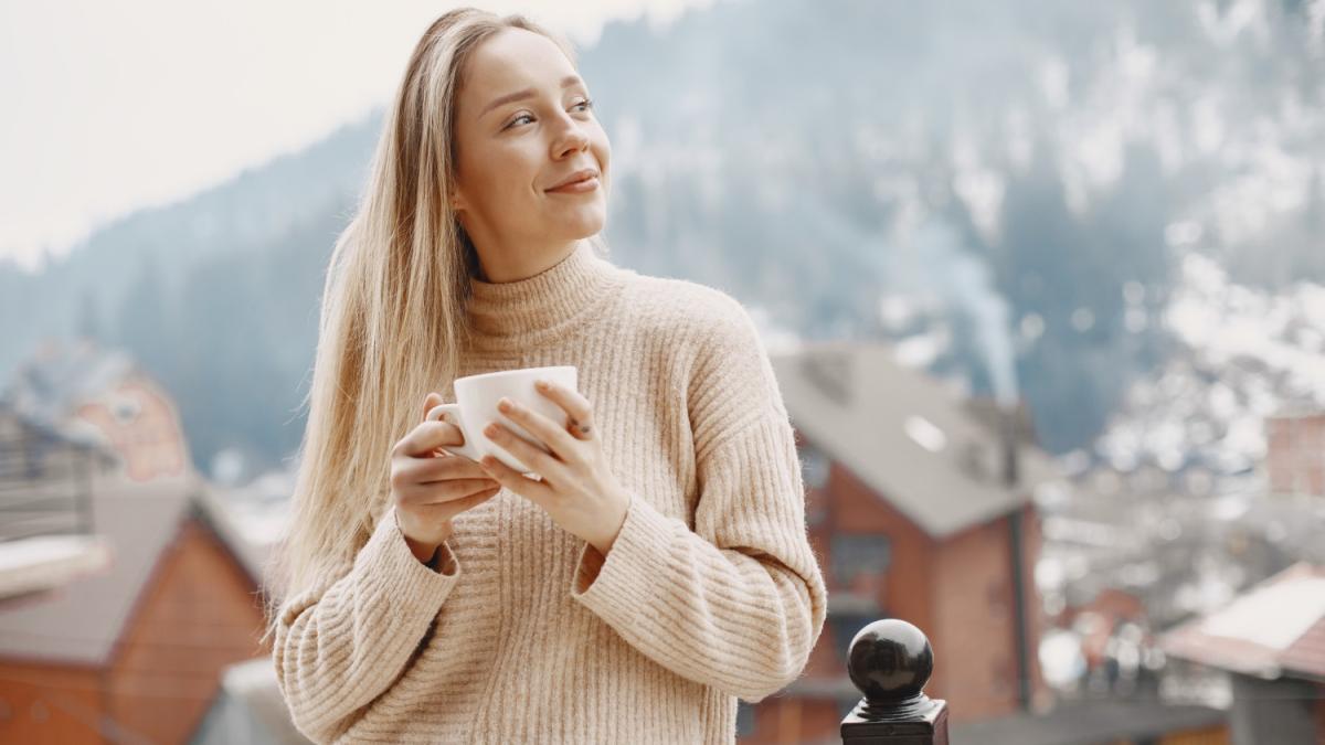 Девушка пьет кофе в горах