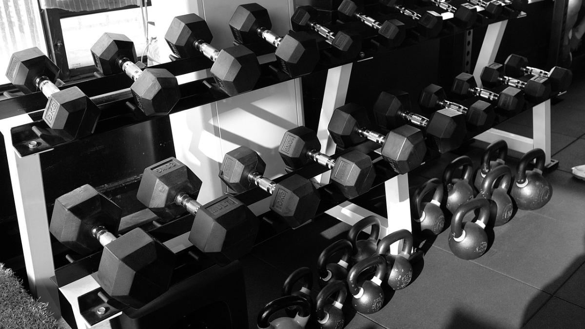 Гантели (разный вес) лежат на полу в спортзале