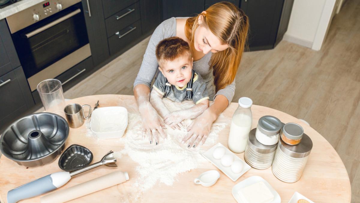 Ребенок помогает родителям на кухне (месит тесто)