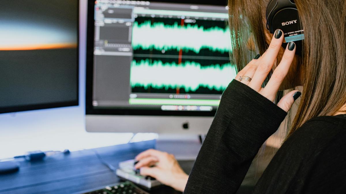 Девушка в больших наушниках работает за компьютером