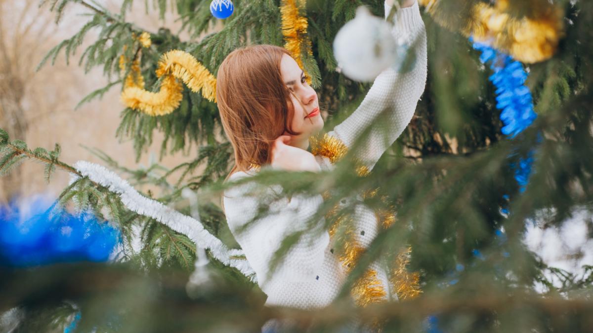 Девушка украшает ель