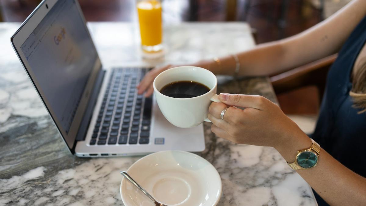 Фрилансер работает за ноутбуком, сидя в кафе