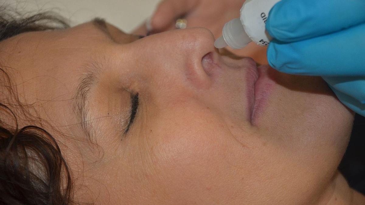 Медицинский работник закапывает капли в нос