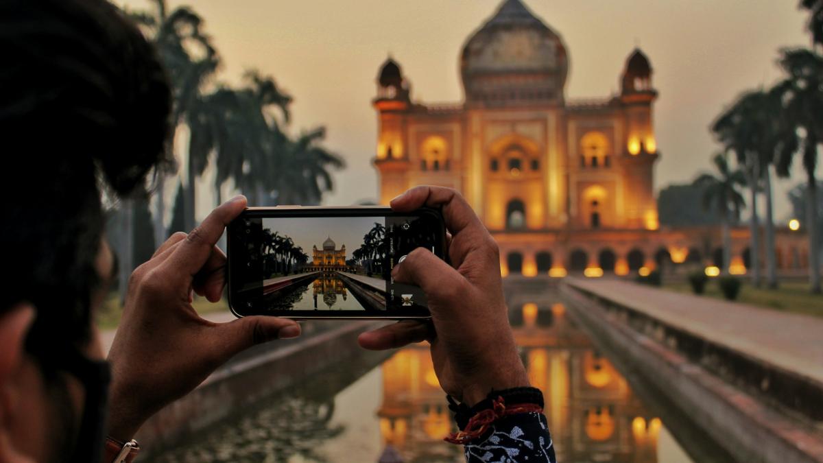 Человек фотографирует достопримечательность на смартфон