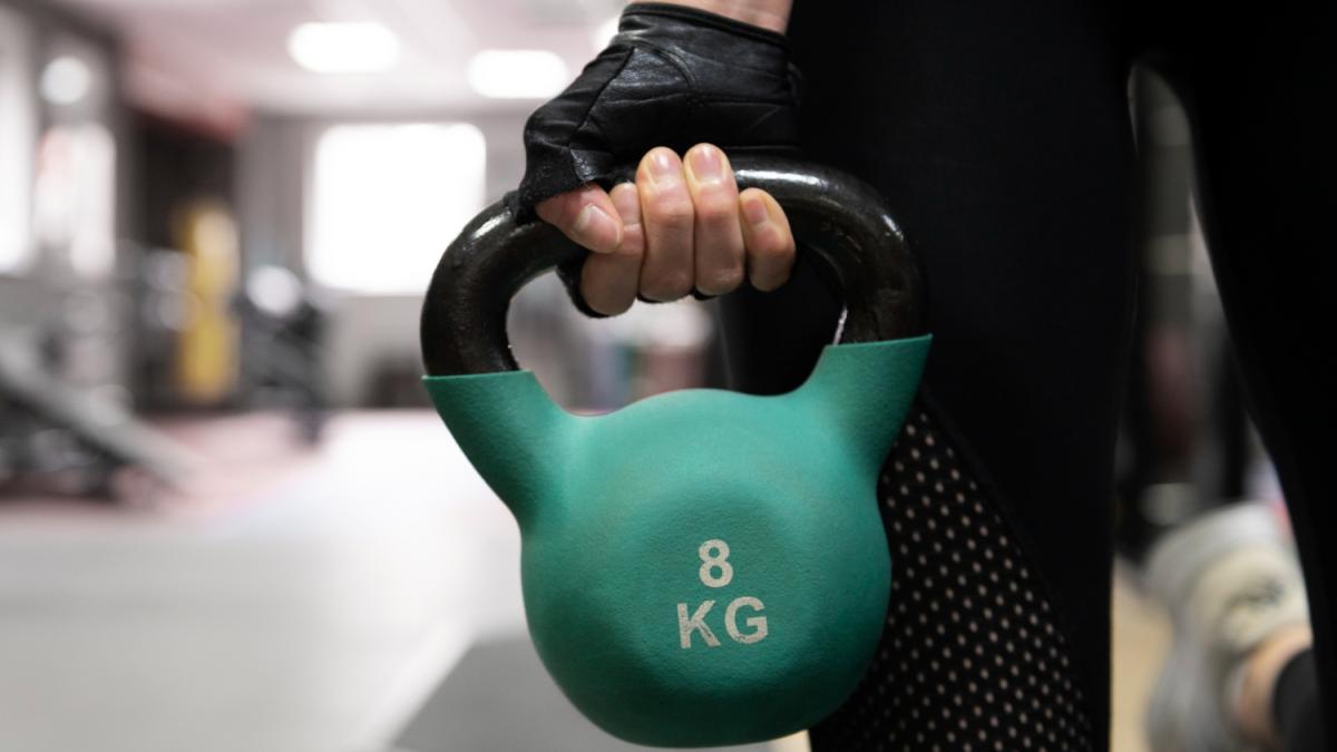 Девушка держит гирю