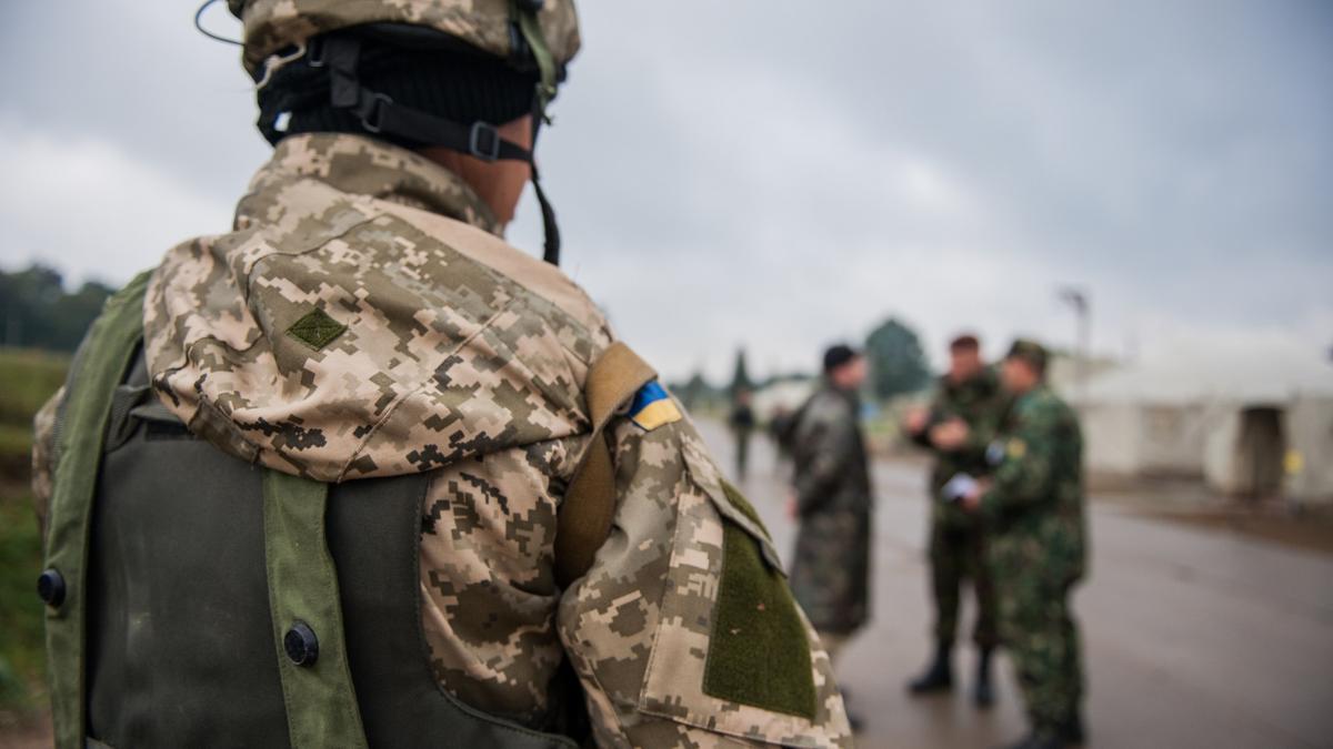 Украинский морской пехотинец наблюдает, как многонациональные участники допрашивают условного солдата Украинский морской пехотинец наблюдает, как многонациональные участники допрашивают условного солдата
