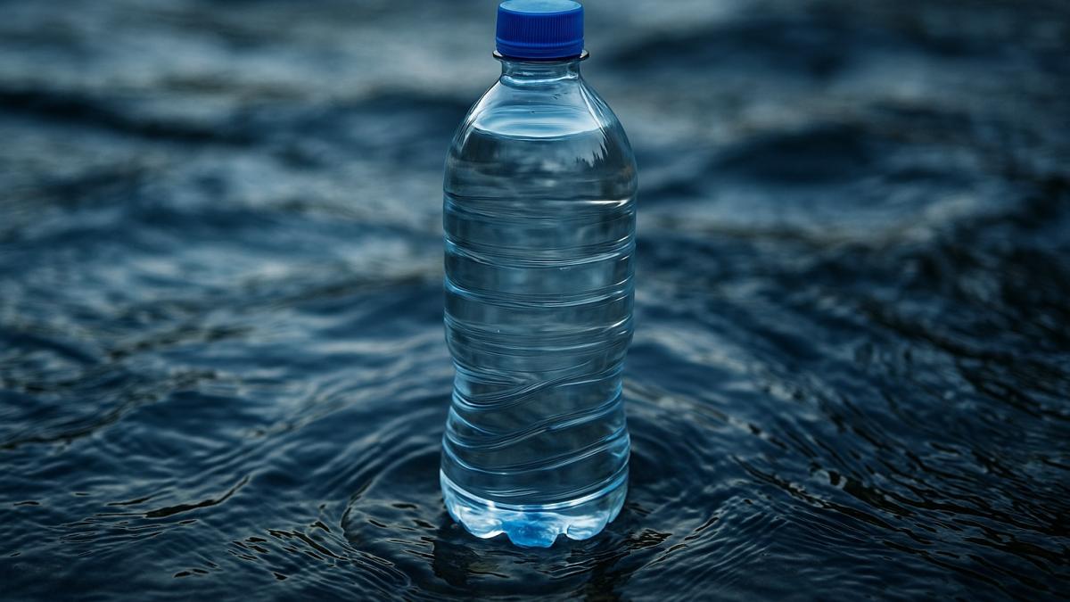 Бутылка воды на фоне волн