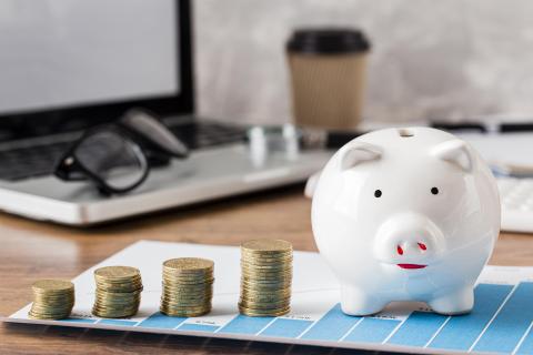 Свинья-копилка и монеты на столе