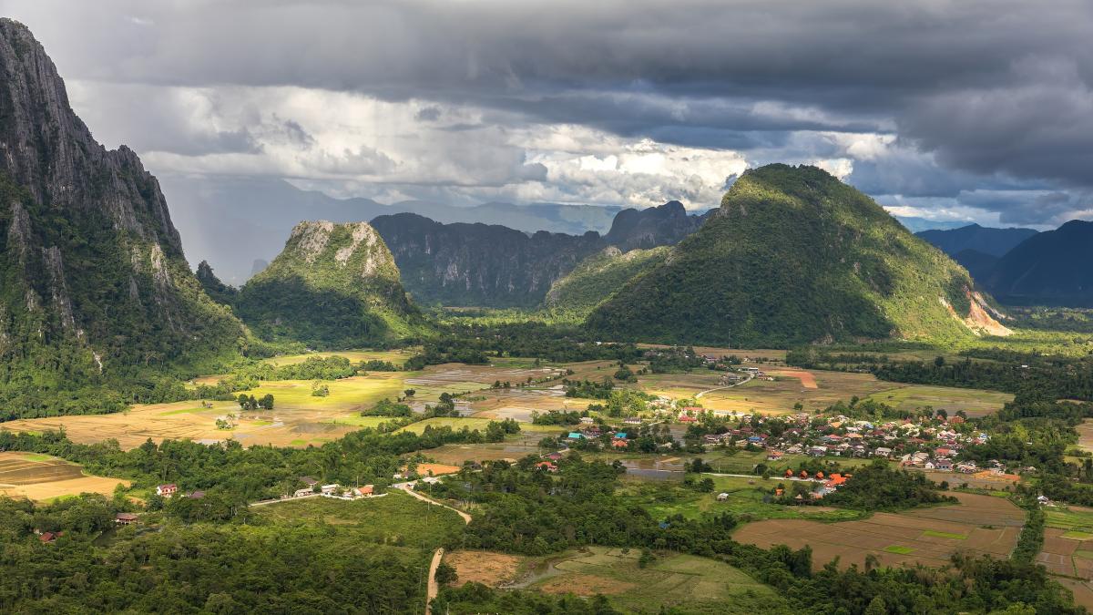 Karst peaks and green paddy fields under a stormy sky, South view from Mount Nam Xay, Vang Vieng, Laos Karst peaks and green paddy fields under a stormy sky, South view from Mount Nam Xay, Vang Vieng, Laos
